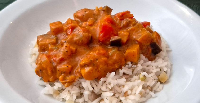 Kip Tikka Masala met notenrijst op een bord